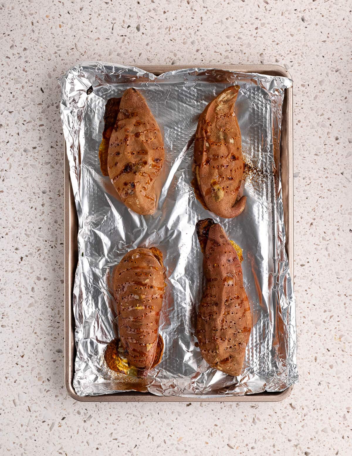 baked sweet potatoes on an aluminum foil lined sheet pan.