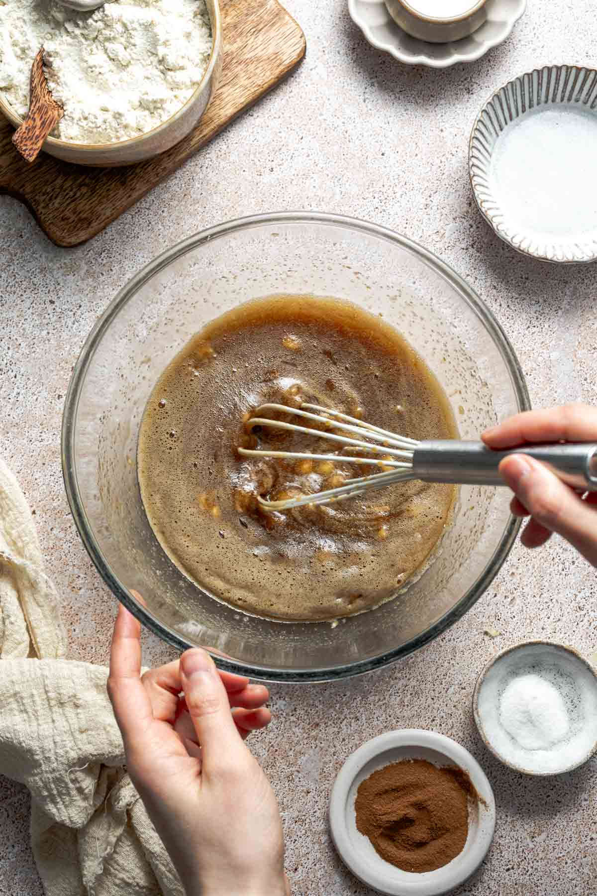 whisking eggs, sugar, and mashed banana together. 