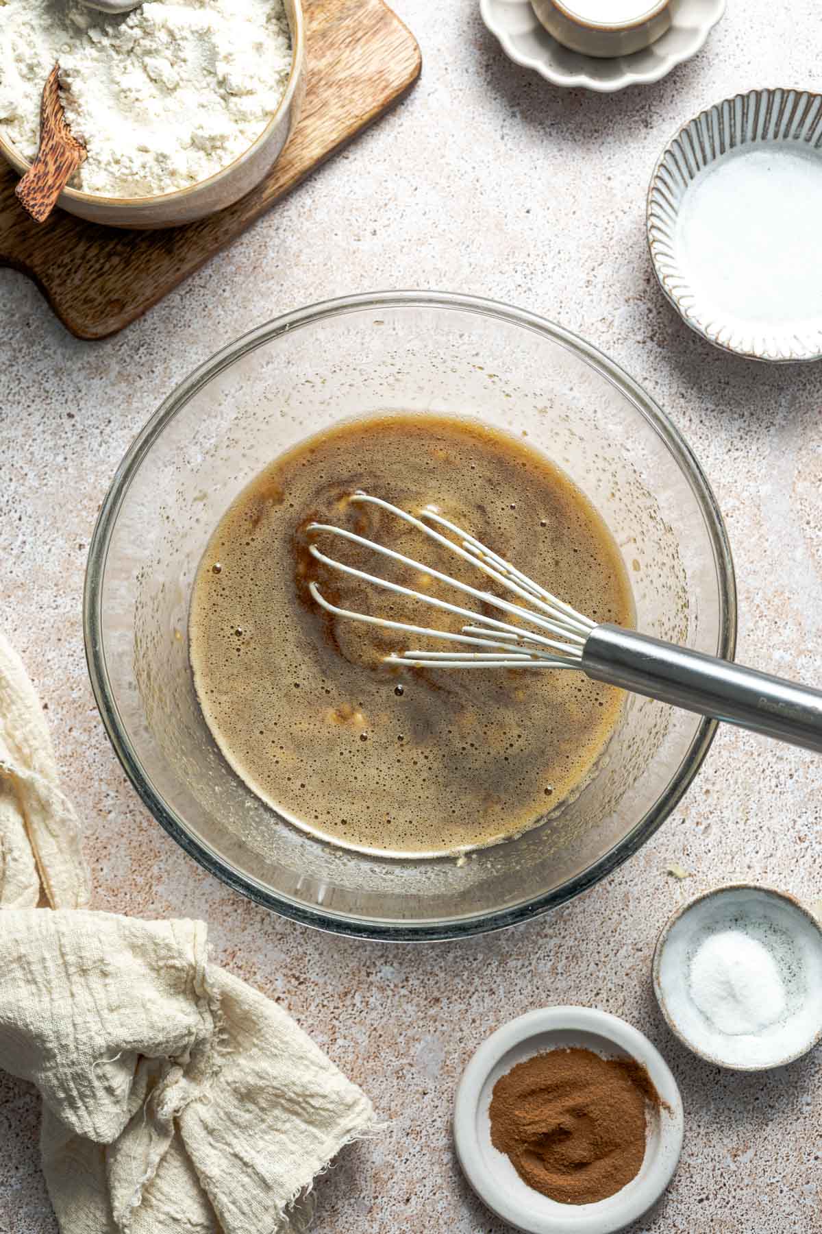a bowl of sugar, mashed banana, and eggs whisked together.