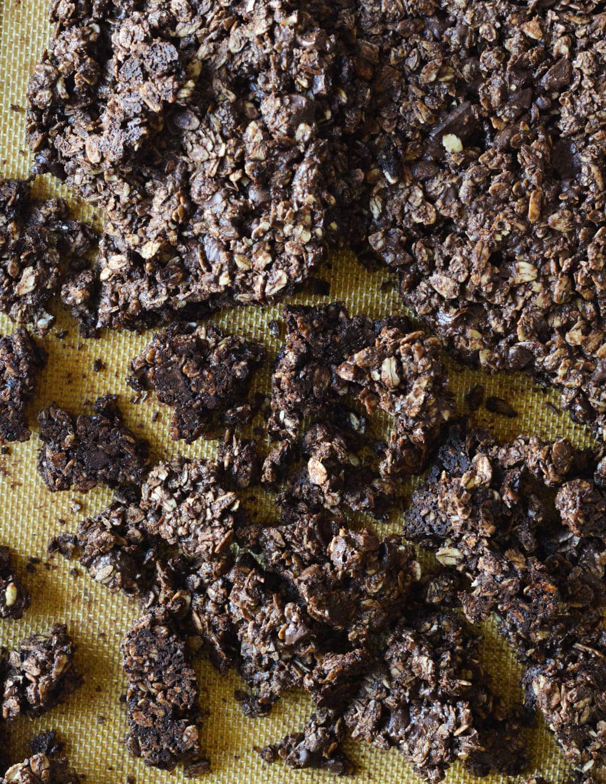 large chocolate granola pieces on a sheet pan.