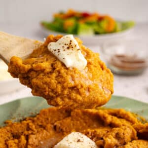a spoonful of mashed sweet potatoes with butter on top.