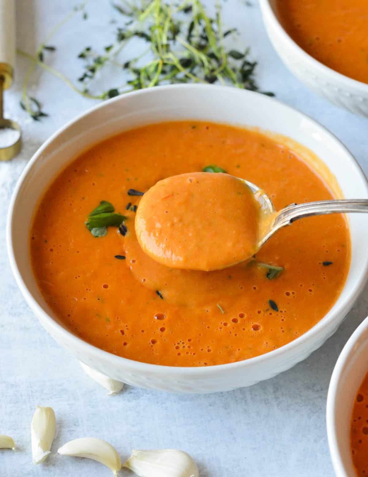 a spoonful of tomato soup over a bowl of it.