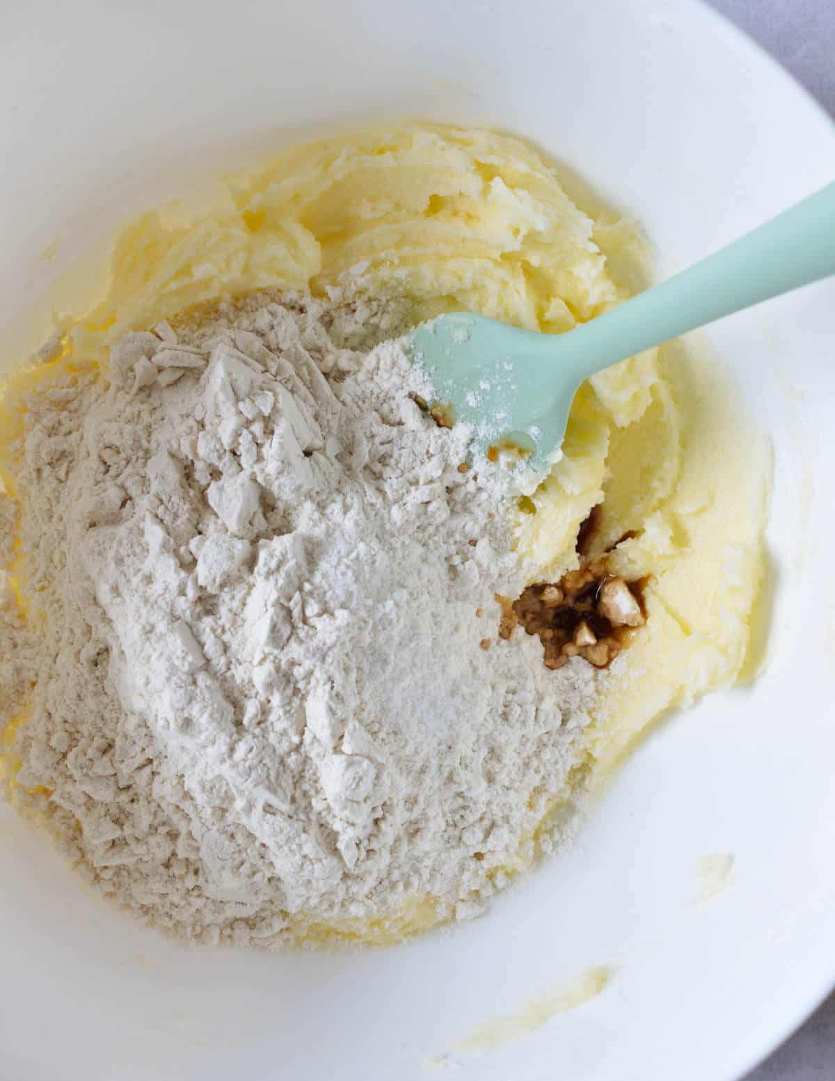 a bowl of creamed butter and sugar with gluten-free flour on top.