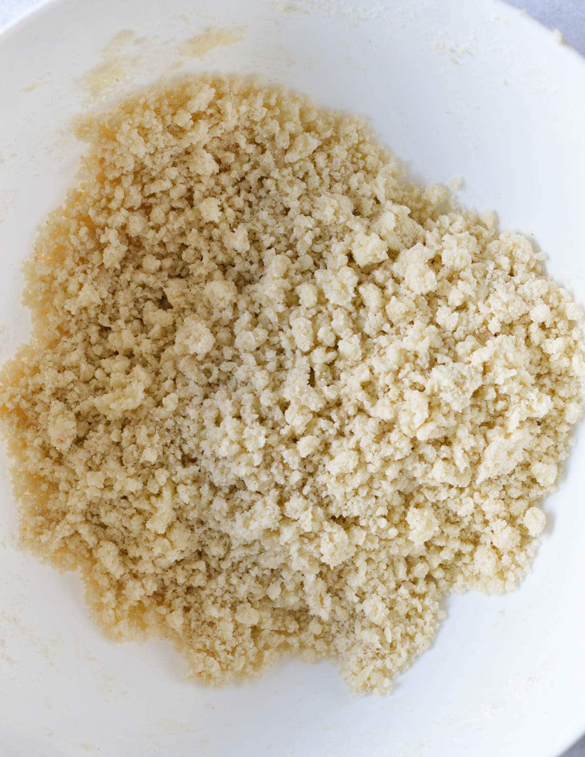 a bowl of gluten free flour, butter, and sugar mixed together in crumbles.