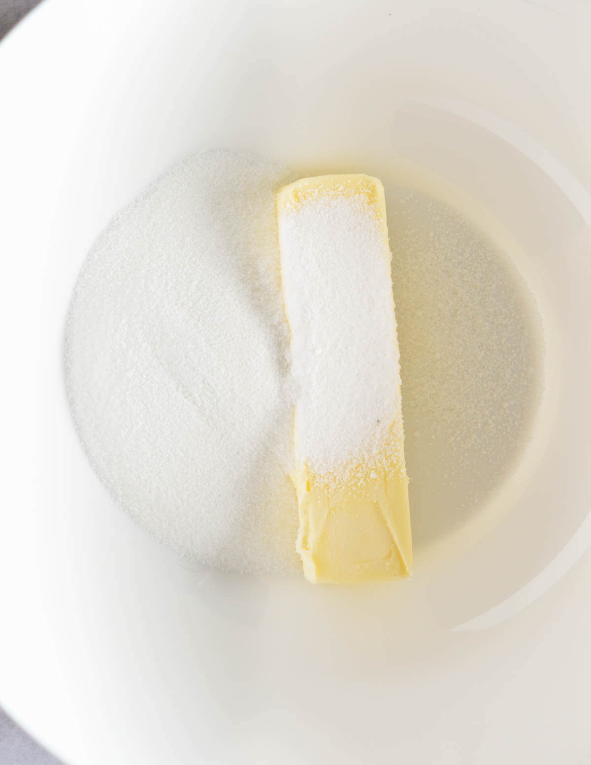 a stick of butter and sugar in a bowl.
