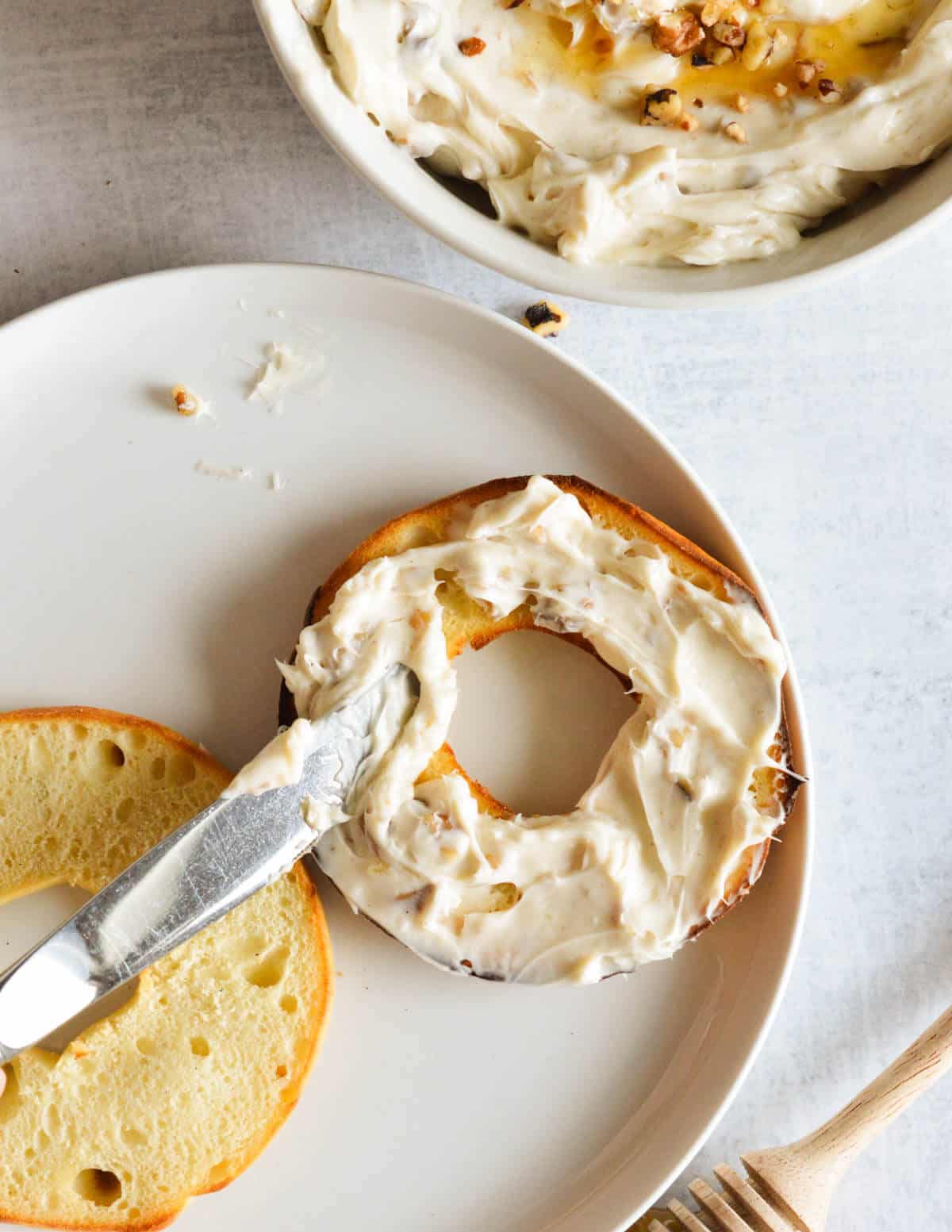 spreading honey walnut cream cheese on a bagel.