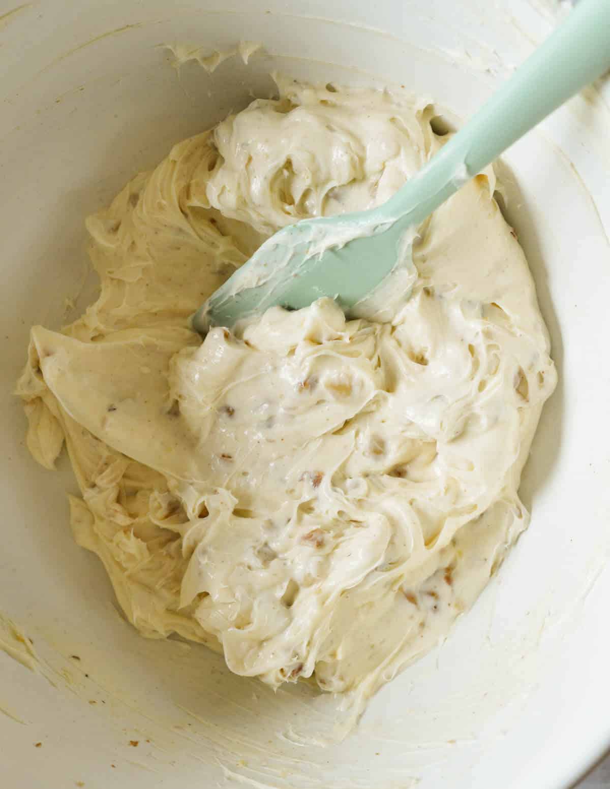 a large bowl with honey walnut cream cheese and a spatula in it.
