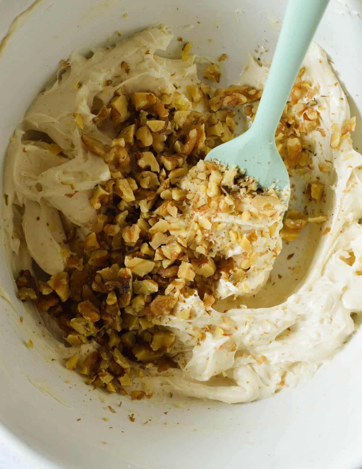 chopped walnuts on honey cream cheese in a bowl.