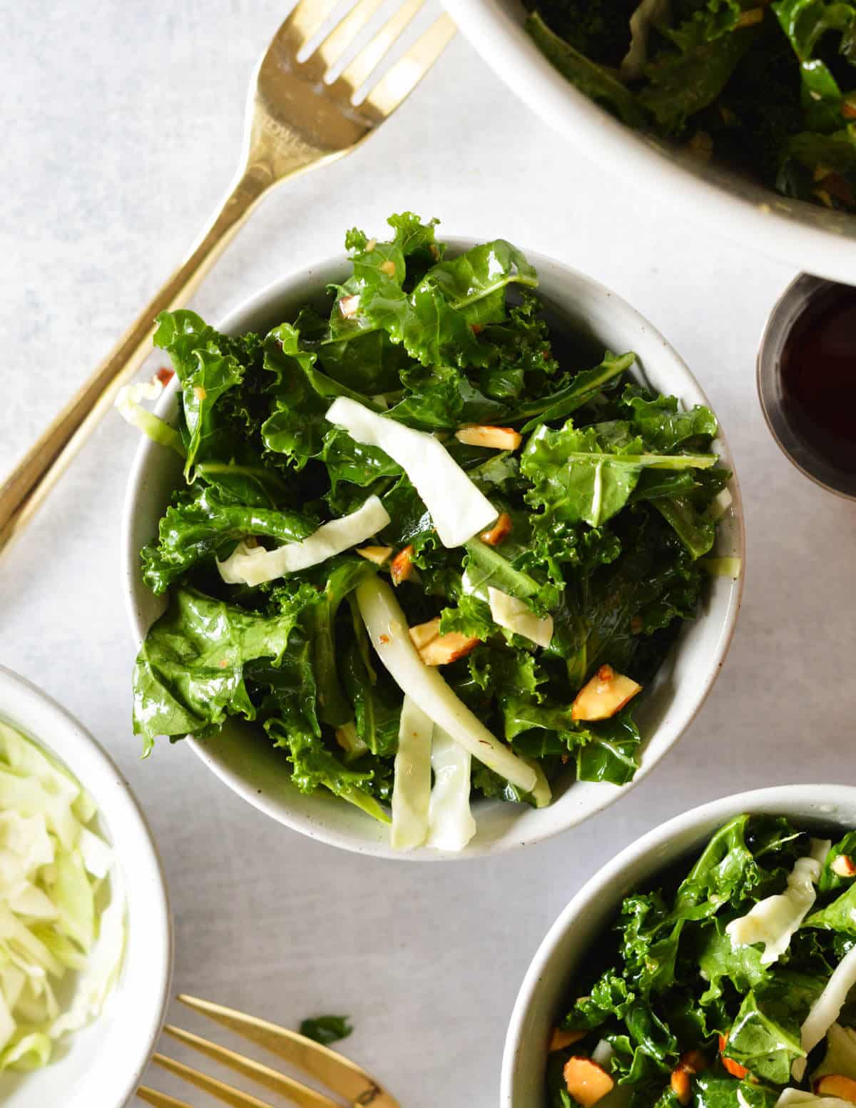 a bowl of kale salad with cabbage and almonds.