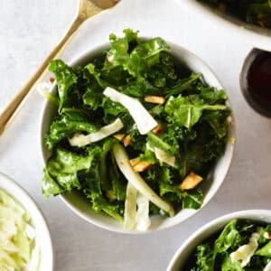 kale salad with cabbage and almonds in a bowl.