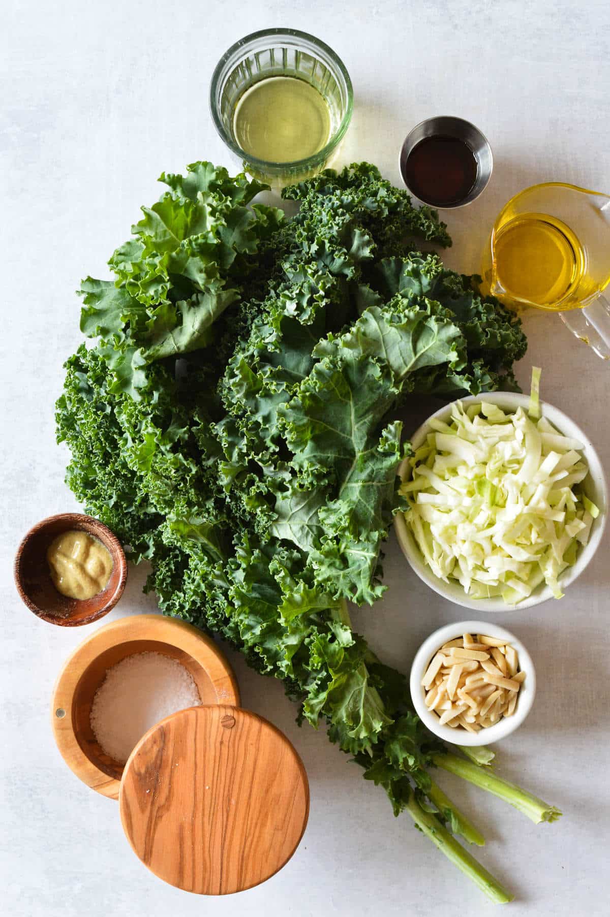 bunch of kale, shredded cabbage, maple syrup, olive oil, white wine vinegar, dijon mustard, kosher salt, almonds.