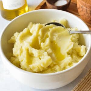 a bowl of mashed potatoes with olive oil on top.