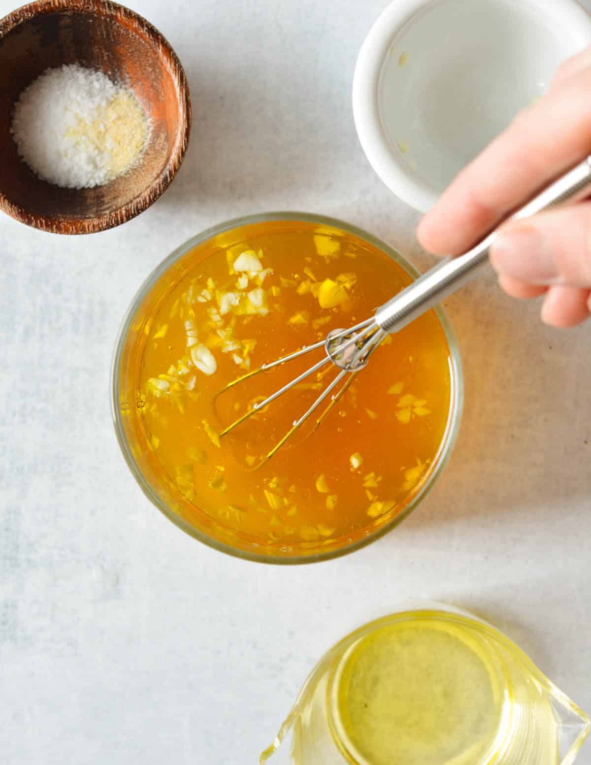 vegetable stock, olive oil, and garlic in a liquid measuring cup.