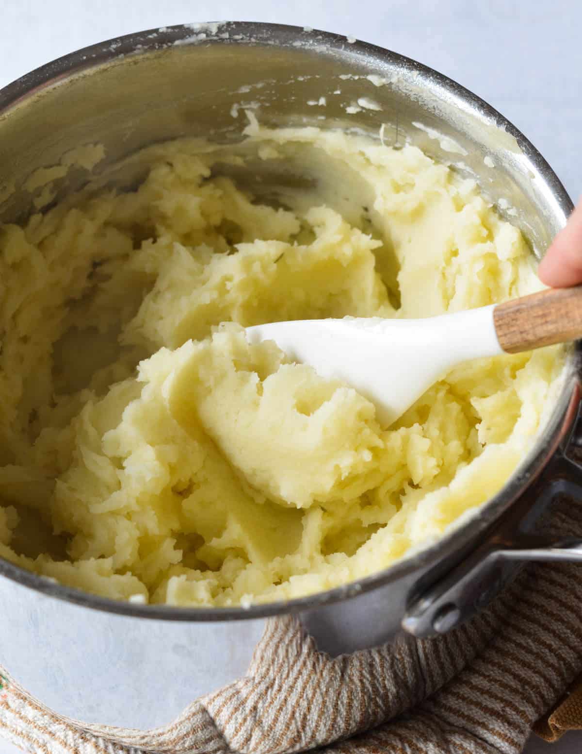 a pot of mashed potatoes with a spatula in it.