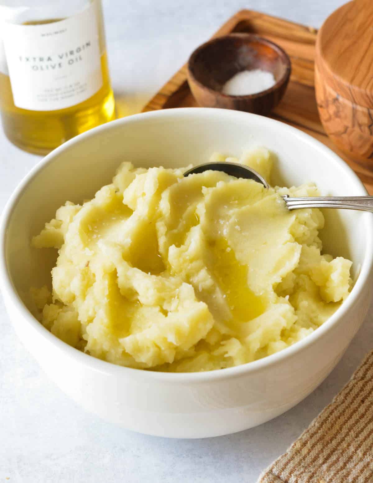 a bowl of creamy mashed potatoes with olive oil.