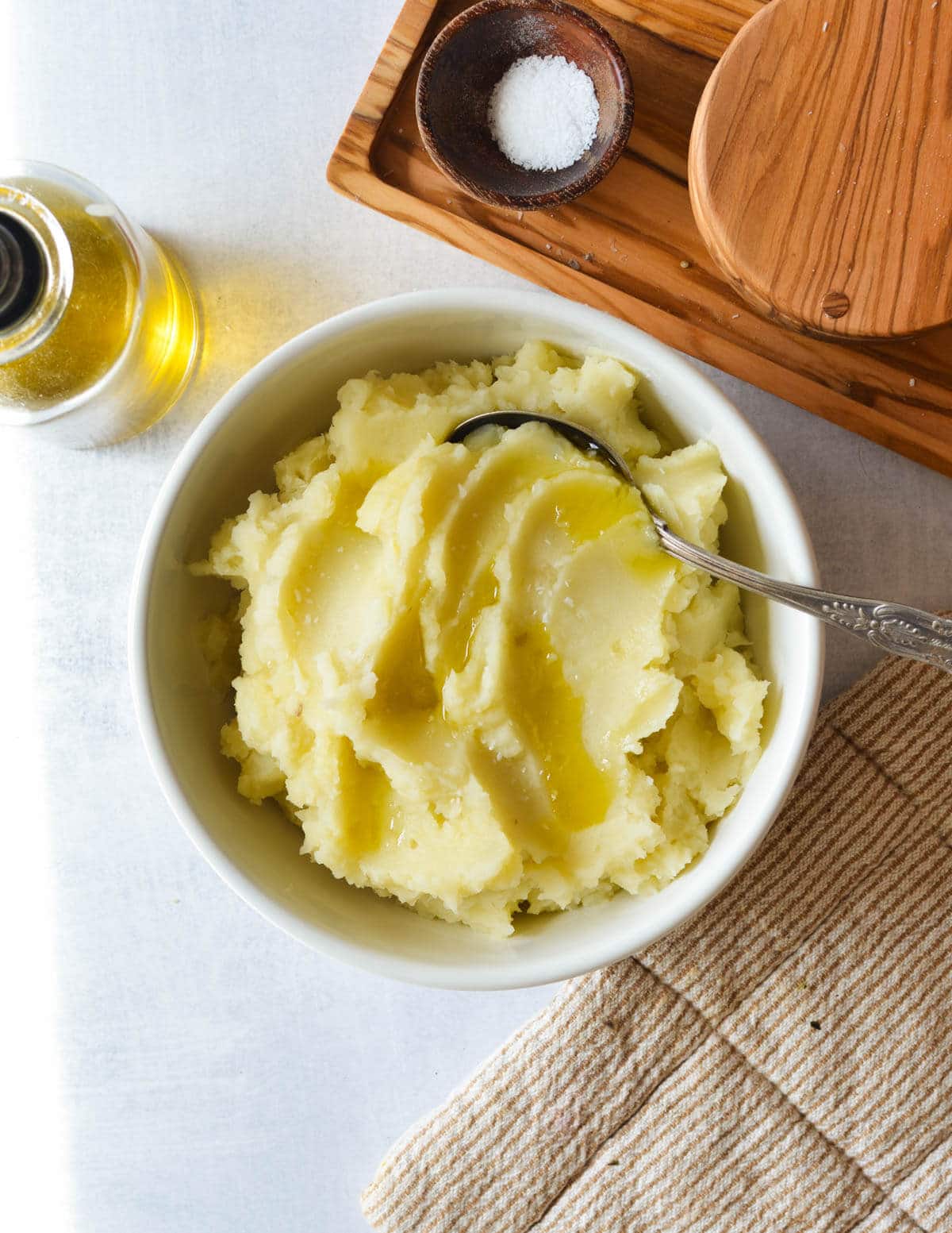 a bowl of mashed potatoes with olive oil and salt on top.
