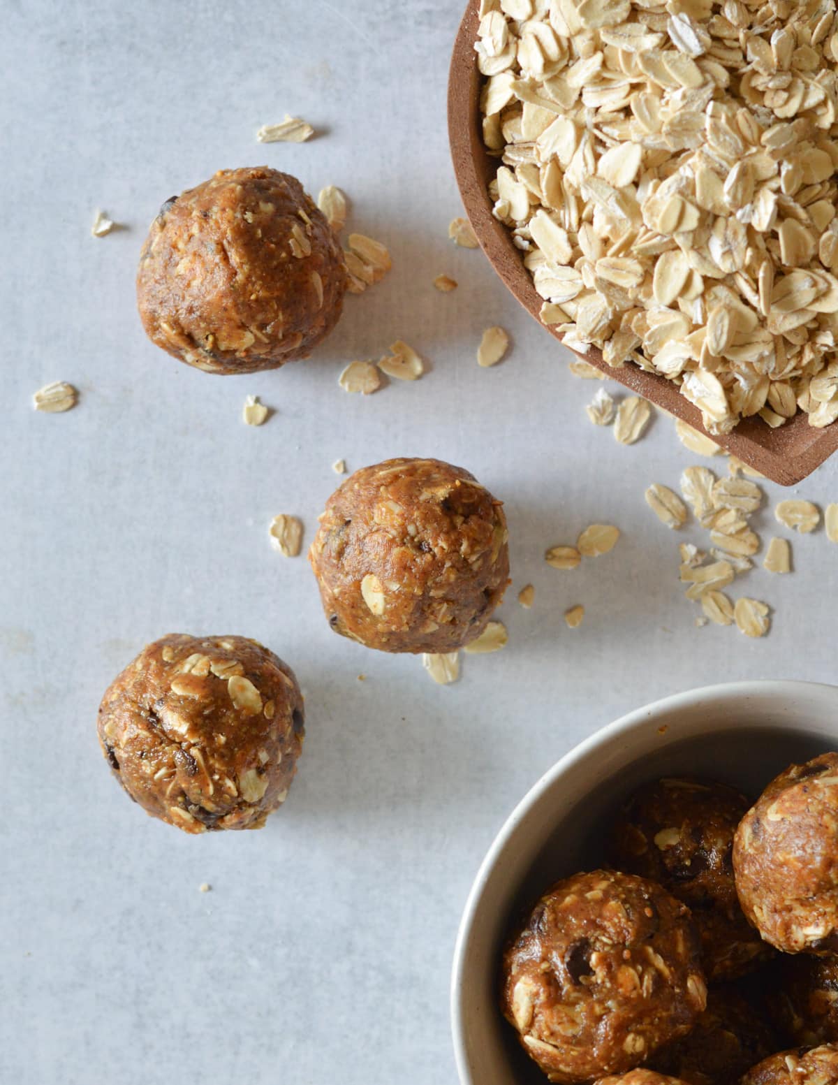 almond butter bites on the counter near a bowl of oats.