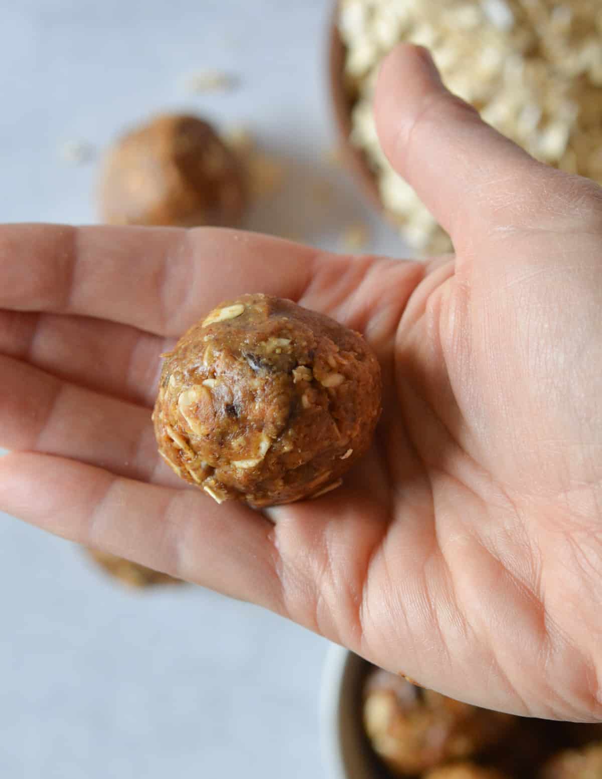 hand holding an almond butter energy ball.