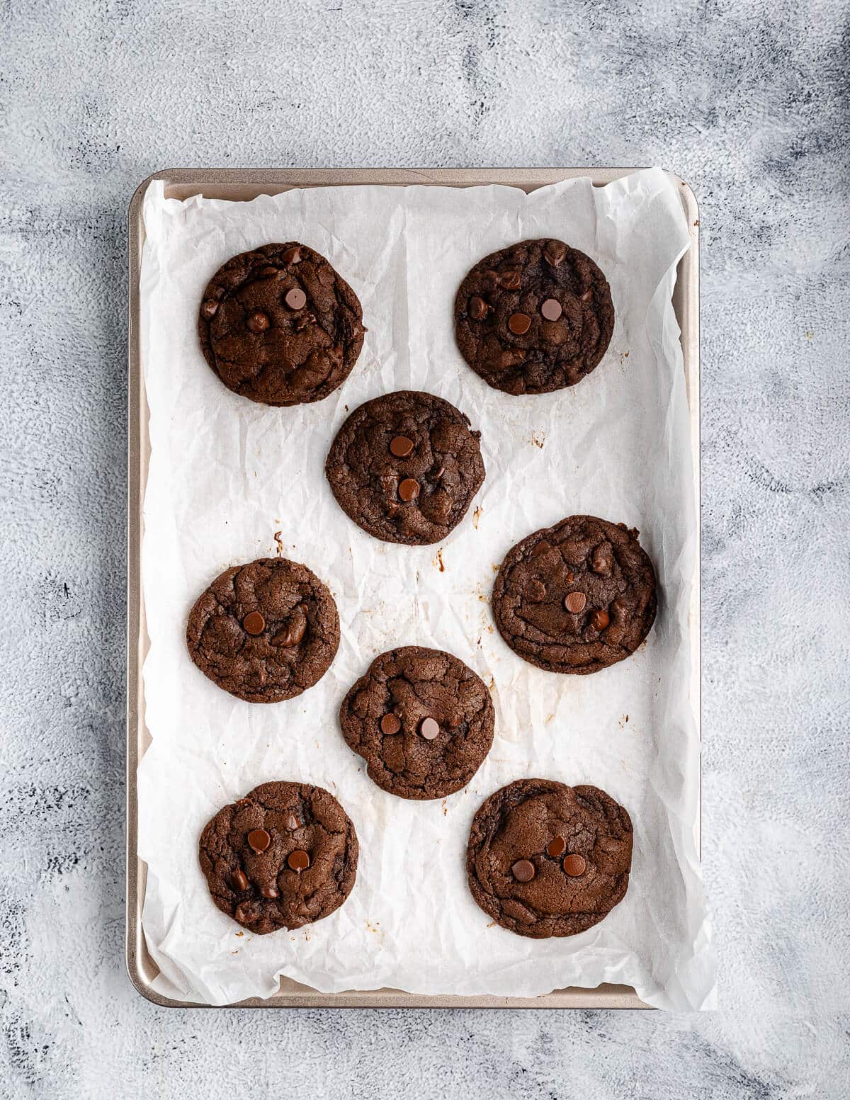 baked chocolate cookies on a sheet pan.