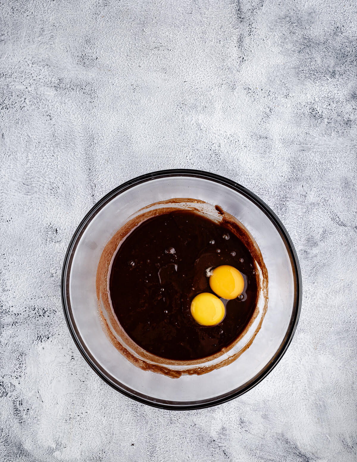 a bowl of melted chocolate with eggs on top.