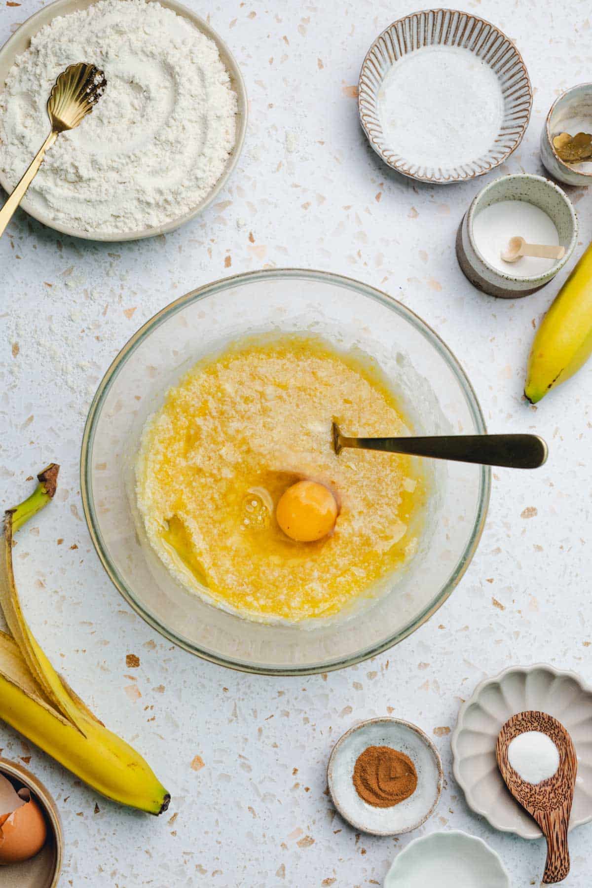 a mixture of mashed banana, oil, and honey with an egg on top.