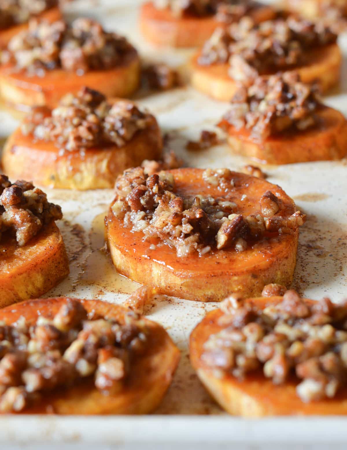 roasted sweet potato sliced with candied pecans on top.