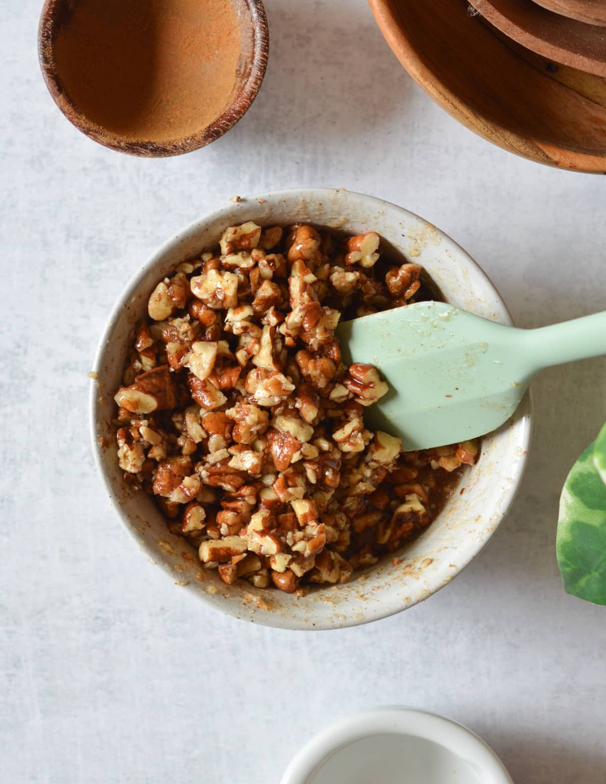 a bowl of chopped pecans coated in maple syrup and butter.