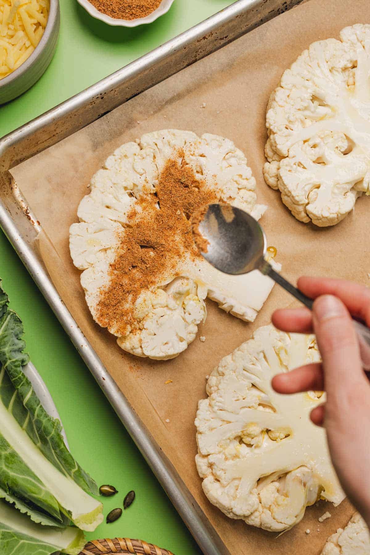 sprinkling taco seasoning onto cauliflower steaks