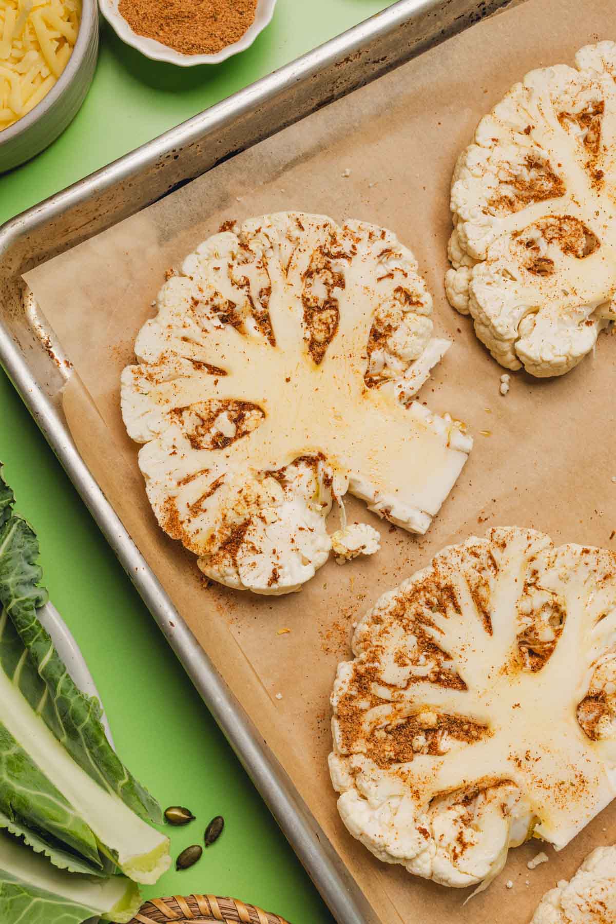 seasoned cauliflower steaks on a sheet pan
