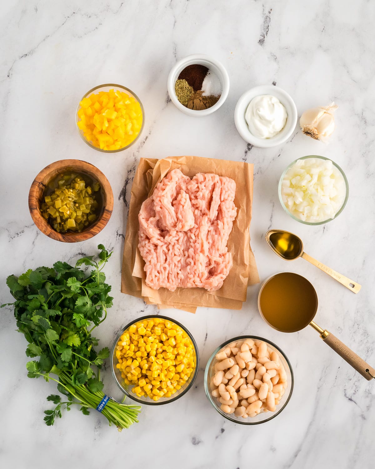 ground chicken, spices, diced bell pepper, diced onion, sour cream, garlic, green chiles, chicken stock, olive oil, cilantro, corn and white beans.