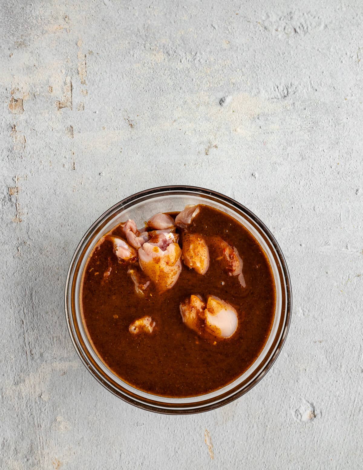 a bowl of chicken thighs in a chipotle marinade.
