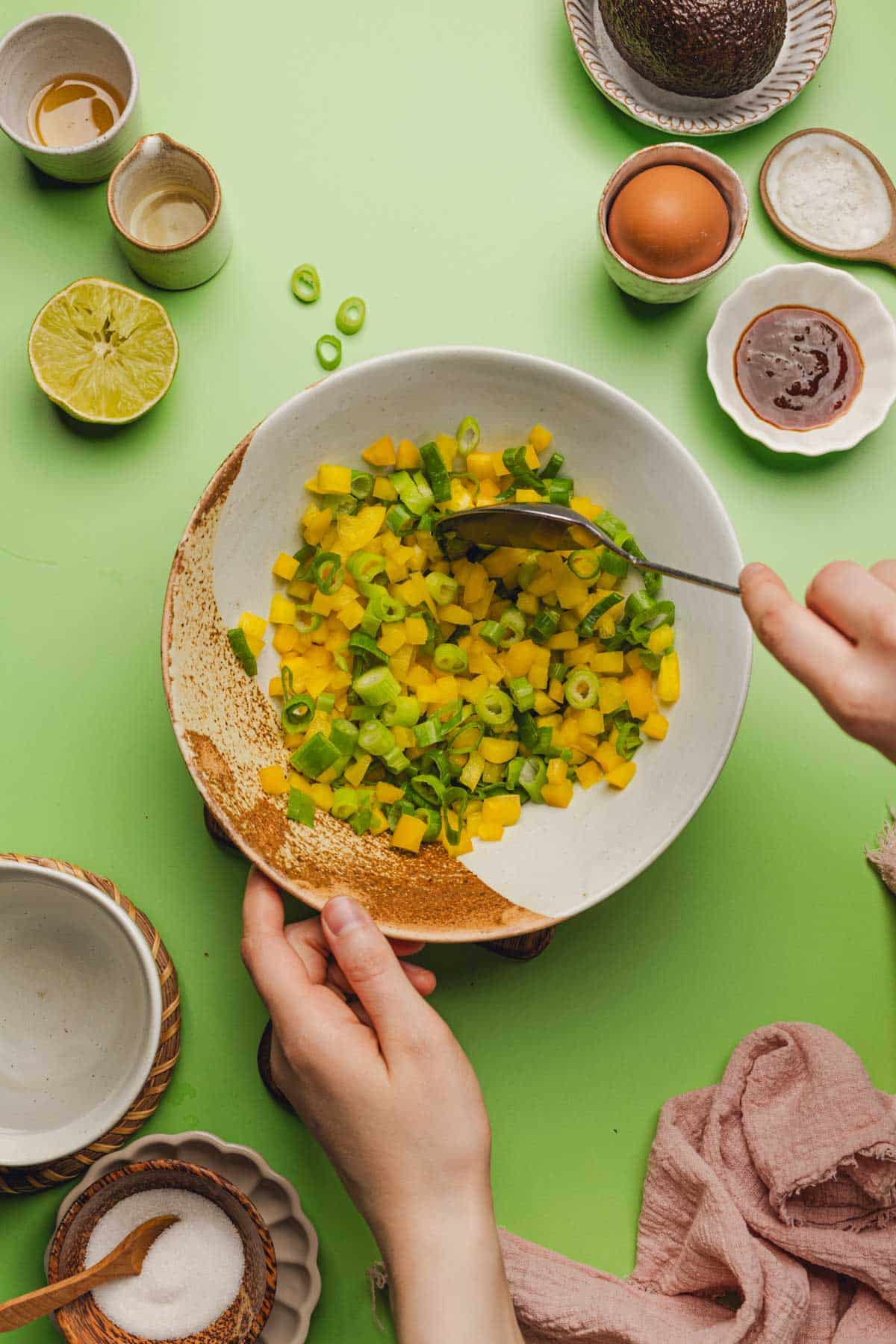 a bowl of diced yellow bell peppers and sliced green onions.