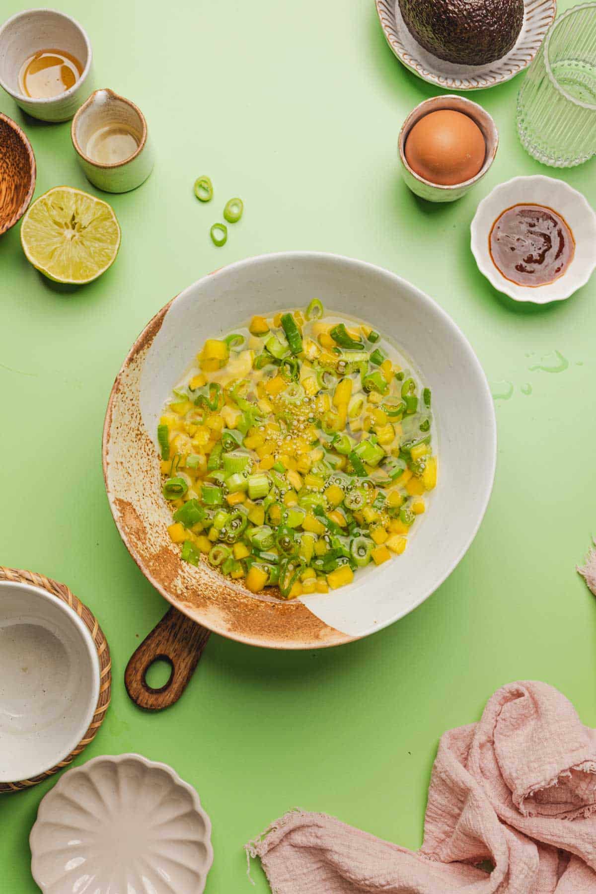 a bowl of pickled yellow bell peppers and green onions.