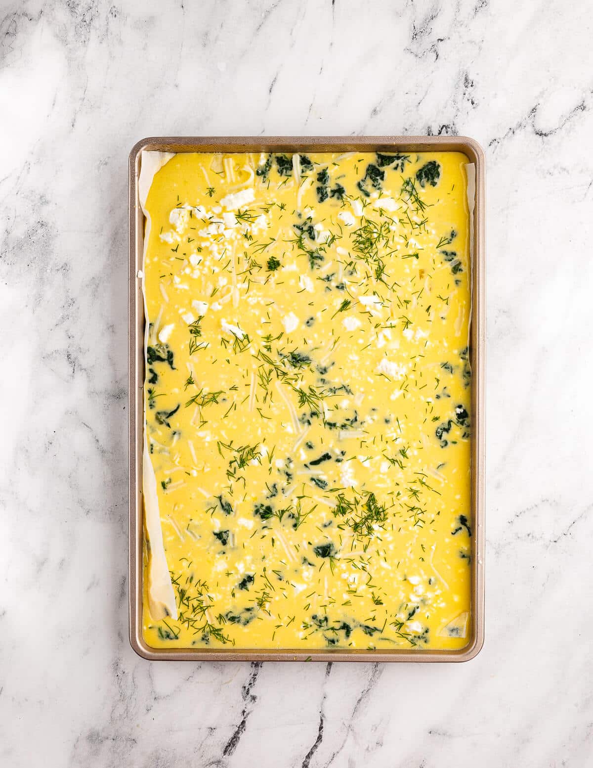 whisked eggs, feta, spinach, and mozzarella in a sheet pan.