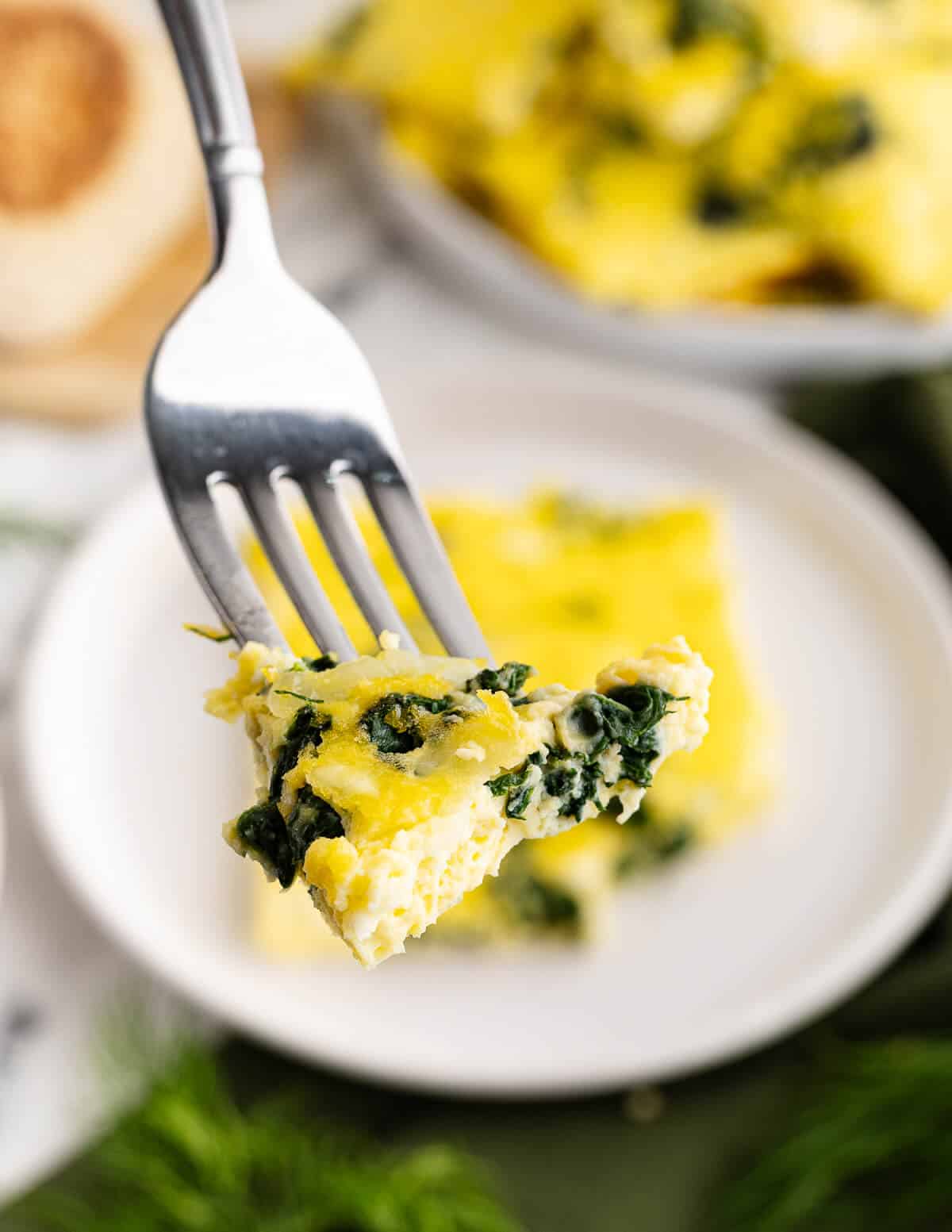 a bite of cooked eggs with spinach and cheese.