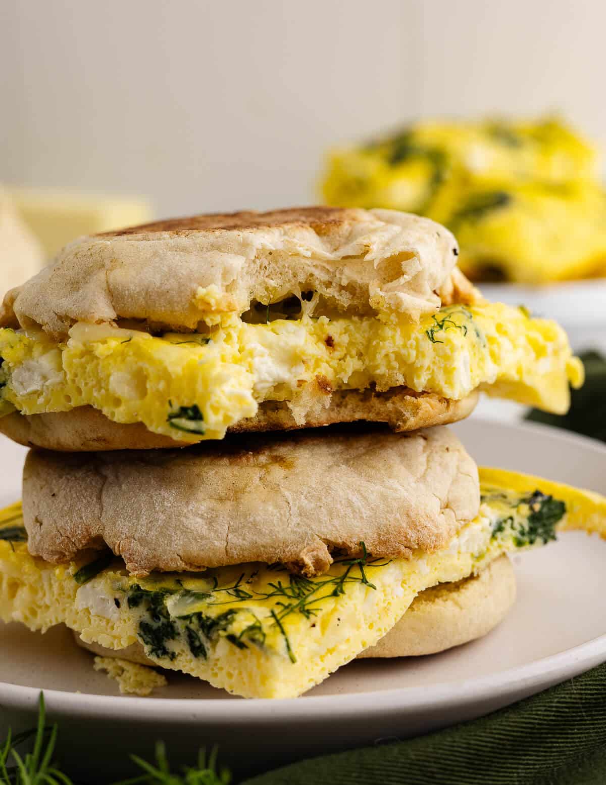 two egg sandwiches stacked on a plate.