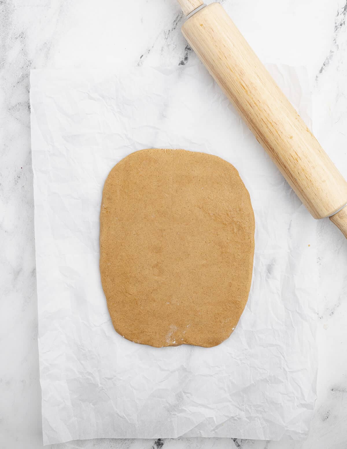 rolled out gluten-free cookie dough into a rectangle with a rolling pin next to it.