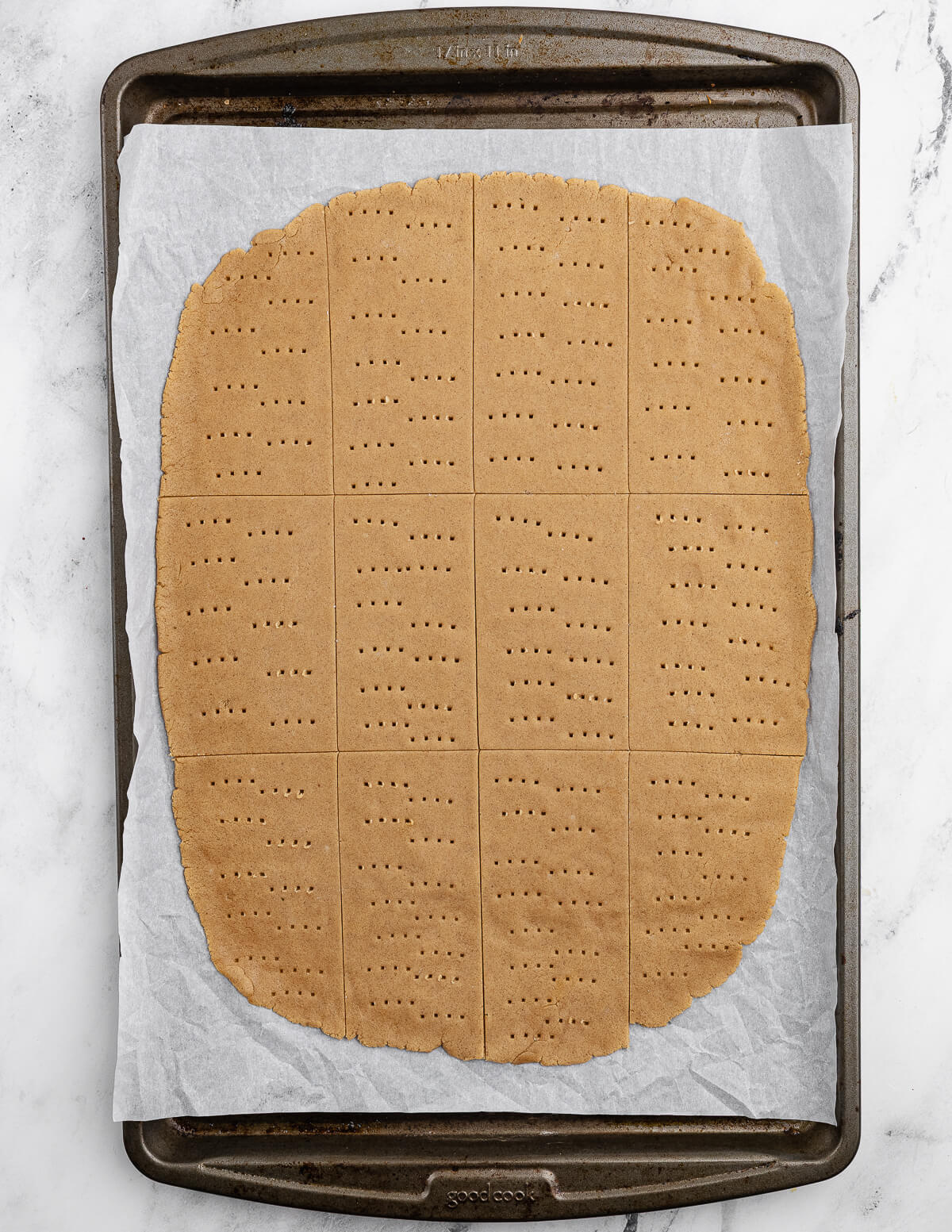 rolled out graham cracker cookie dough on a sheet pan.