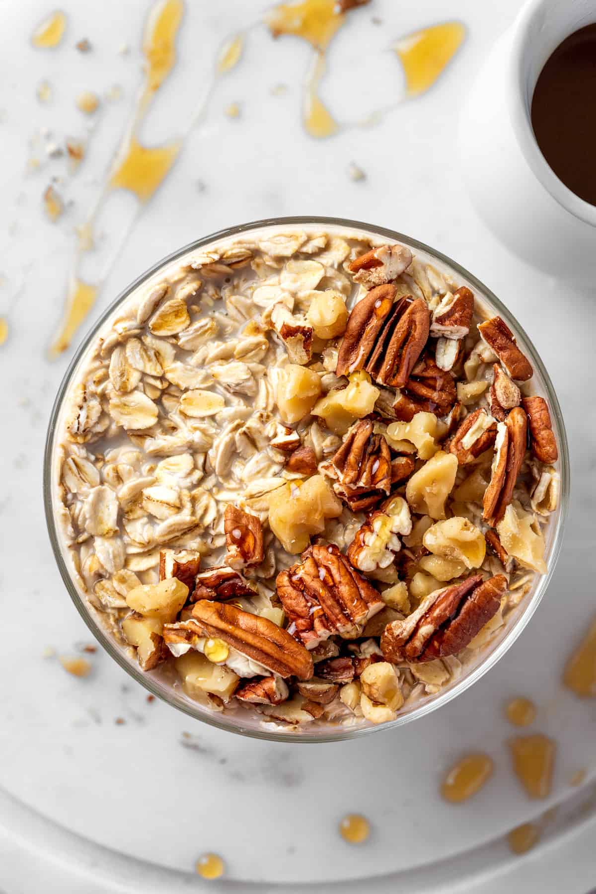 the top of a glass with overnight oats, pecans, and walnuts.