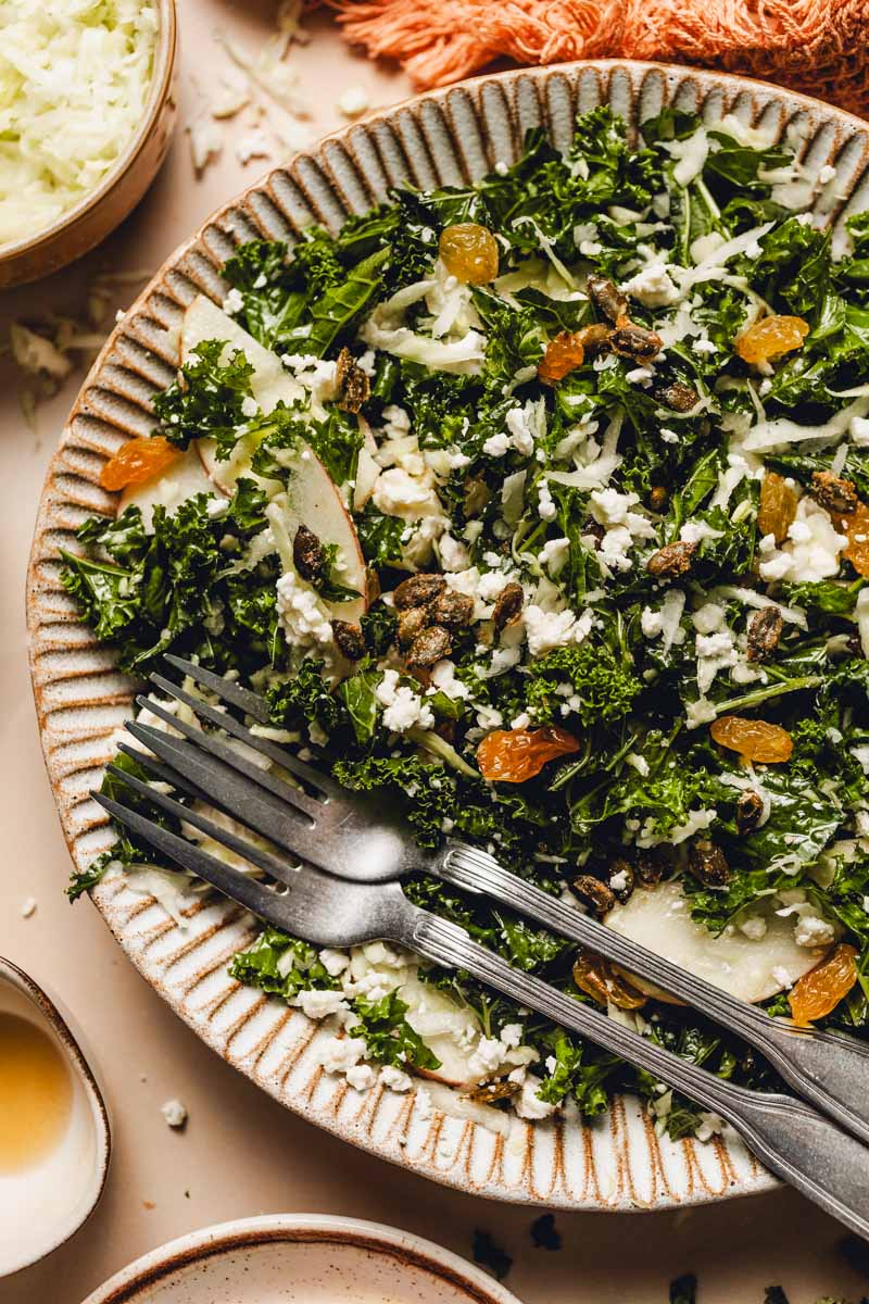 kale salad with feta, golden raisins, maple pepitas, and sliced apples.