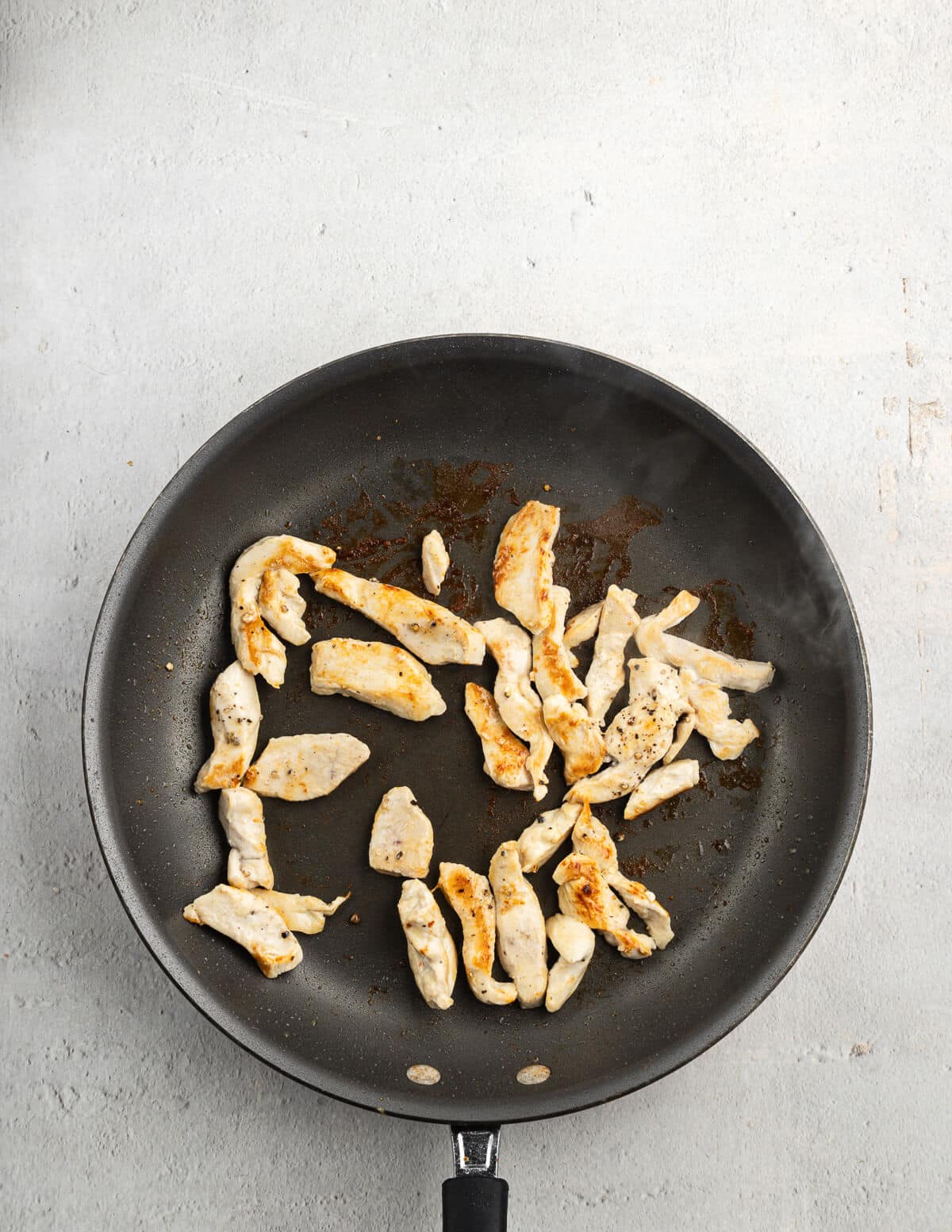 small pieces of cooked chicken in a skillet.