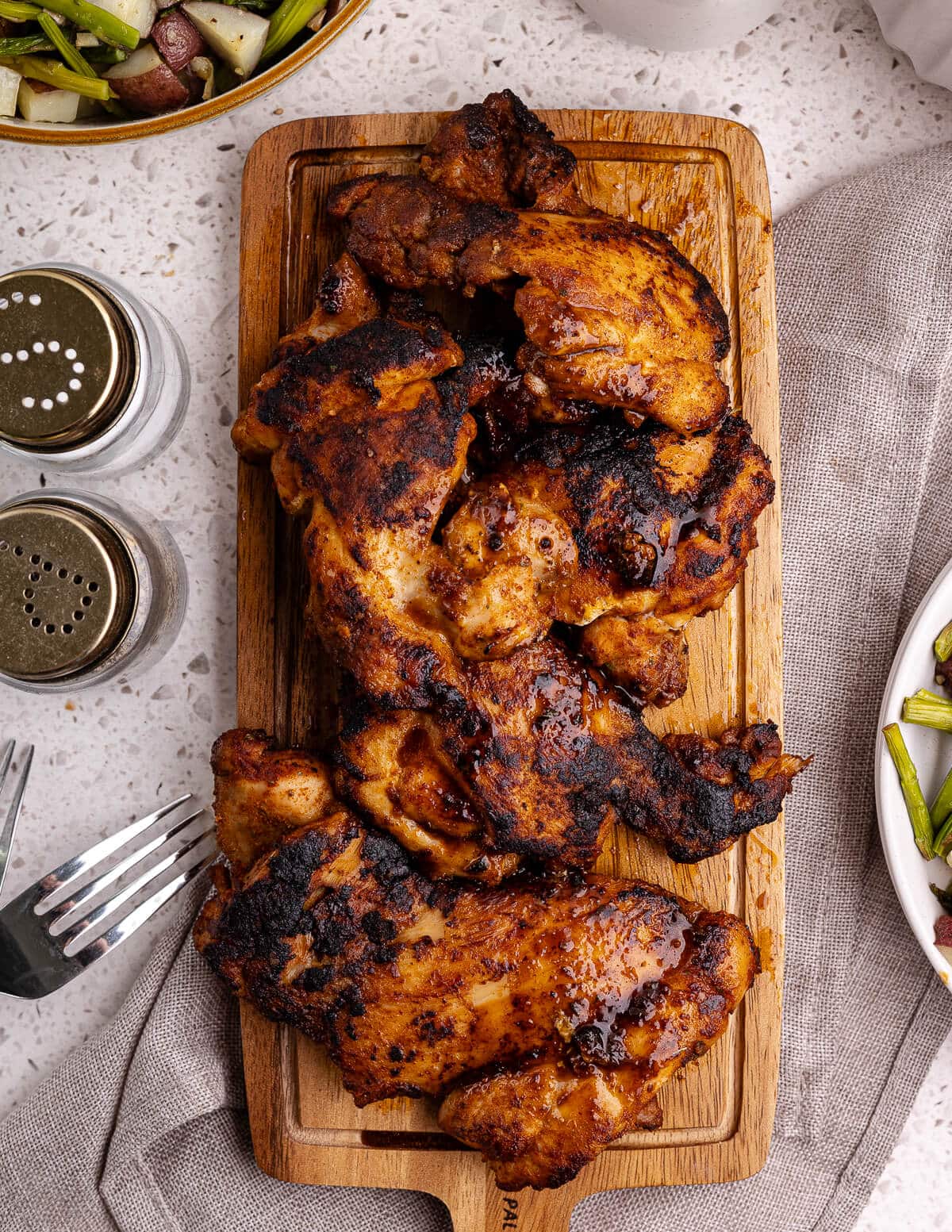 cooked boneless skinless chicken thighs on a cutting board.