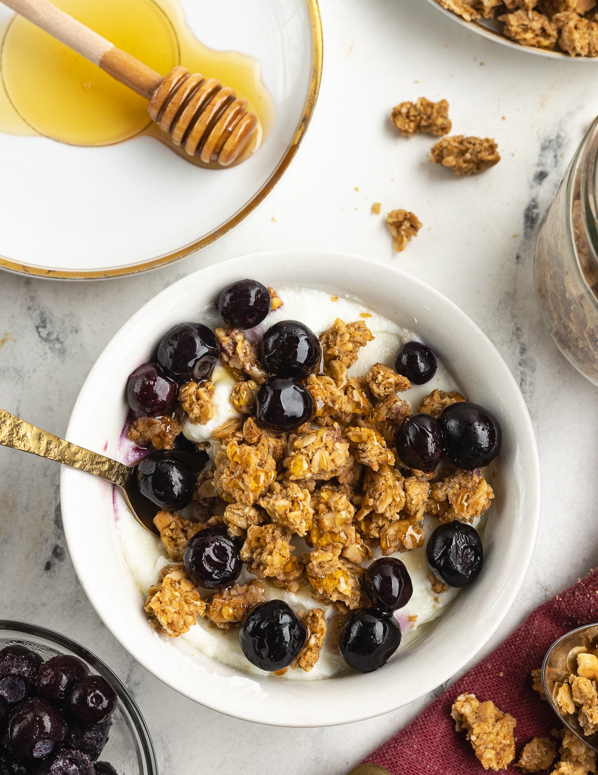 a bowl of granola and blueberries over yogurt.