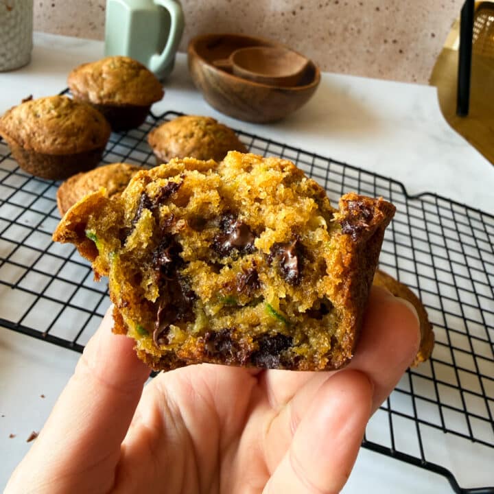 hand holding half a zucchini muffin