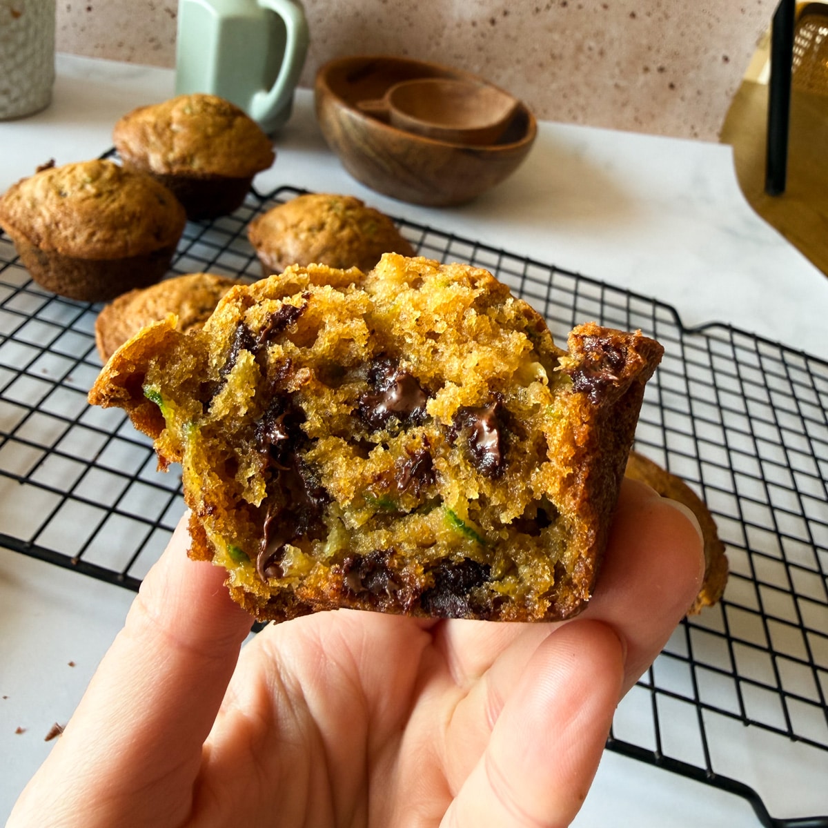 hand holding half a zucchini muffin