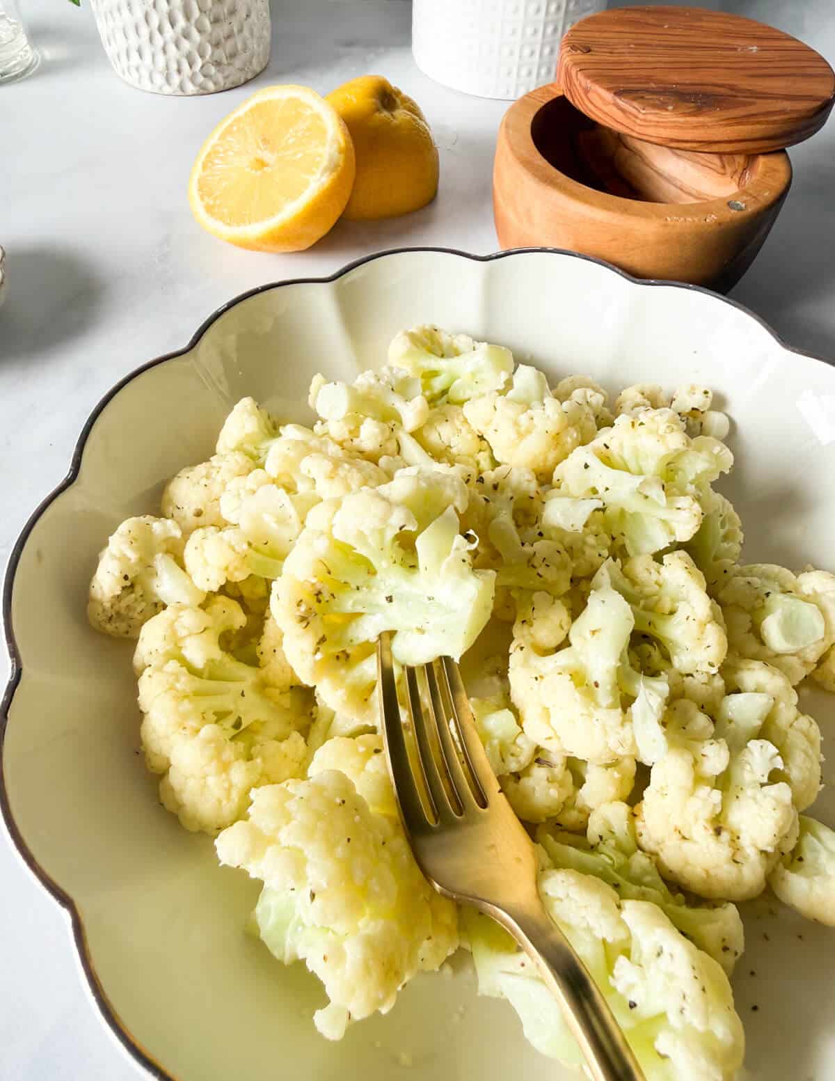 a bowl of steamed cauliflower with garlic butter sauce.