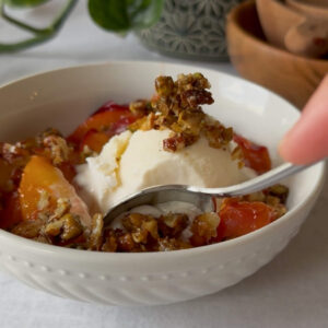 a bowl of caramelized peaches with vanilla ice cream on top