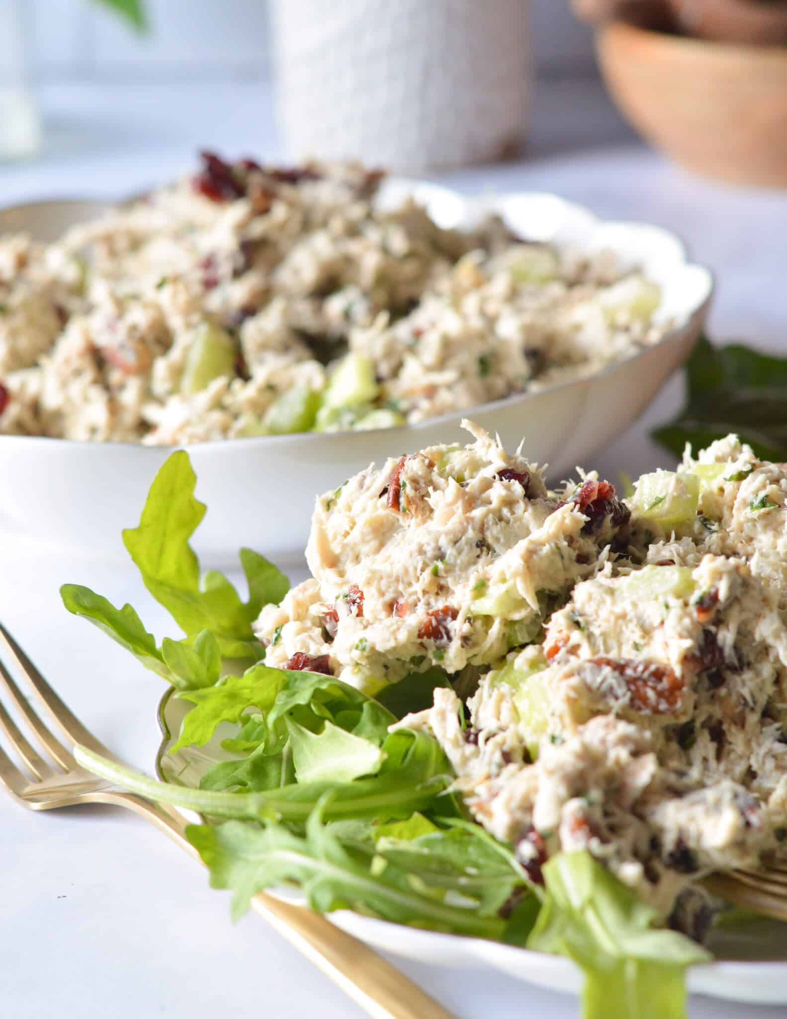scoops of basil chicken salad on arugula
